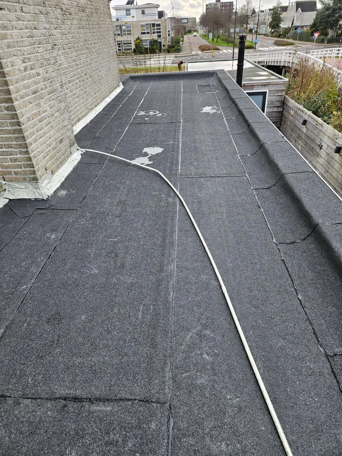 Bitumen dakbedekking op een plat dak met schoorsteen in Heerhugowaard, Noord-Holland